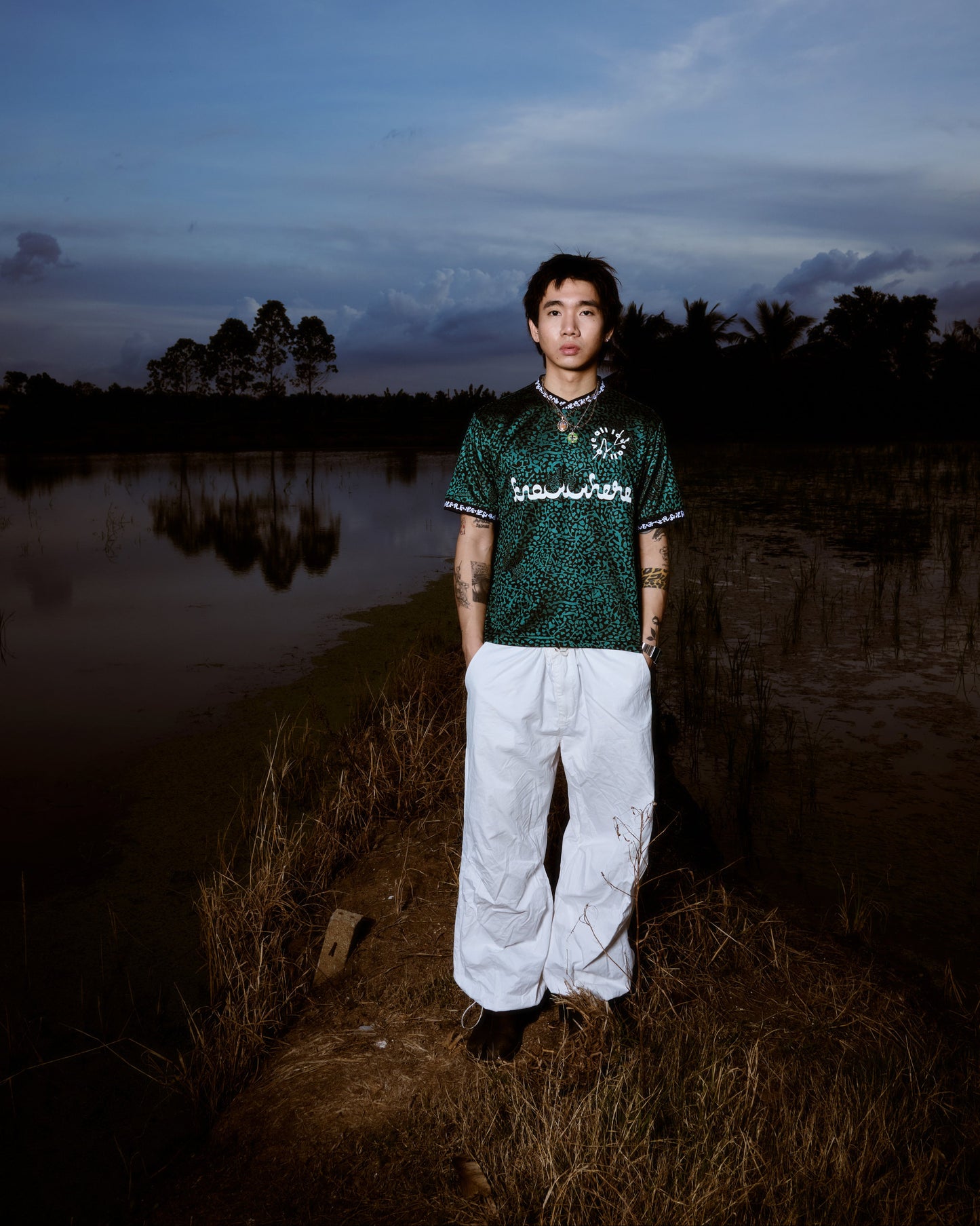 Person standing by a body of water with a dark sky