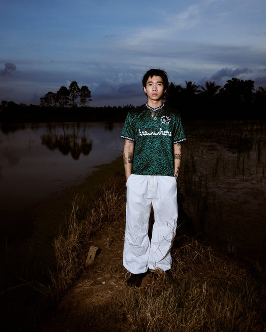 Person standing by a body of water with a dark sky