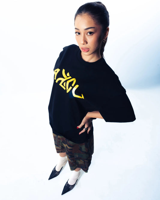 Person wearing a black t shirt with yellow text on a white background